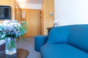 a room with a blue chair and a vase of flowers at Haus der Begegnung in Innsbruck