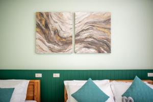 a bedroom with a bed and a painting on the wall at Turtle Tales - Tao Yaa in Thai Muang