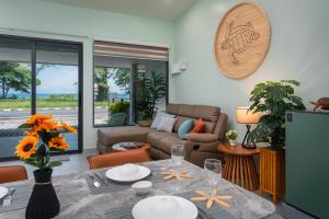 a living room with a table and a couch at Turtle Tales - Tao Yaa in Thai Muang