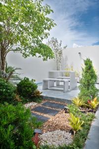 a garden with a bench in the middle of a yard at Turtle Tales - Tao Yaa in Thai Muang