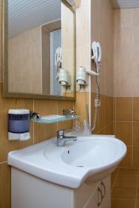 a bathroom with a white sink and a mirror at Vila Verde in Chişinău