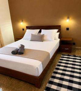 a bedroom with a large bed with white sheets at Le havre des palmiers in Tsivonoabe