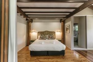 a bedroom with a large white bed with two pillows at The Treehouse - Rainforest Home - Pool in Smithfield