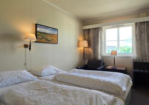 a hotel room with two beds and a window at Idrettsparken in Røros