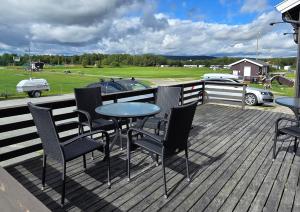 a deck with chairs and a table and a pool at Idrettsparken in Røros