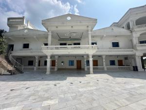 a large white building with a large courtyard at White place hotel and resort in Khānpur