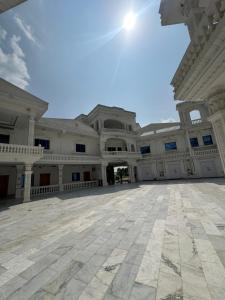 an empty courtyard of a large building with the sun in the sky at White place hotel and resort in Khānpur
