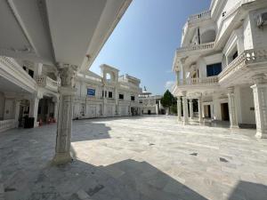 an empty courtyard of a large white building at White place hotel and resort in Khānpur