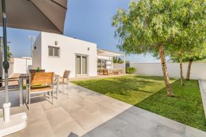 a patio with a table and chairs and a tree at Loft luxury Mirador in Cádiz