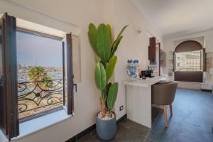 a kitchen with a window and a table with a plant at La Finestra sul Mare di Ortigia Suite Luxury in Syracuse