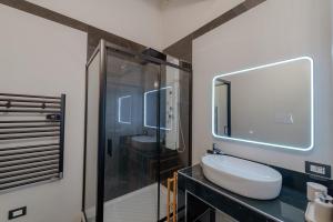a bathroom with a sink and a glass shower at La Finestra sul Mare di Ortigia Suite Luxury in Syracuse +27 photos