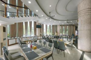 a restaurant with tables and chairs and windows at SAILING TOWER Hotel in Khang Qui