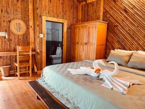 a bedroom with two white swans on a bed at Dung Hoa Resort  +18 photos