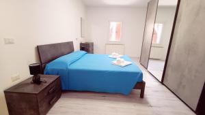 a bedroom with a blue bed and a mirror at Le Mondine in Scardovari