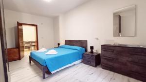 a bedroom with a blue bed and a dresser at Le Mondine in Scardovari