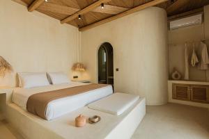 a bedroom with a large bed and a table at Maria's place boutique hotel in Antiparos