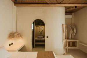 a bedroom with a bed and a mirror in a room at Maria's place boutique hotel in Antiparos +5 photos