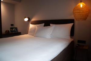 a bedroom with a bed with white sheets and pillows at gambino hotel GOETHE26 in Munich
