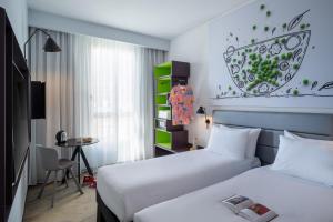 a hotel room with two beds and a table at Ibis Styles Jerusalem City Center - An AccorHotels Brand in Jerusalem