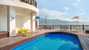 a swimming pool on a deck with a view of the ocean at Namhae Opera House Pension in Namhae