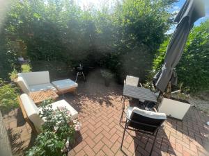 an overhead view of a patio with chairs and an umbrella at "Smart Studio" I Die Hotel Alternative - mehr Freiraum auf 50qm plus Gartenterrasse in Haselünne