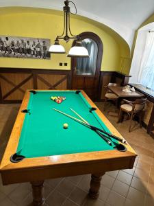 a pool table with two cuesticks on top of it at Apartmány Sladký sen in Kežmarok