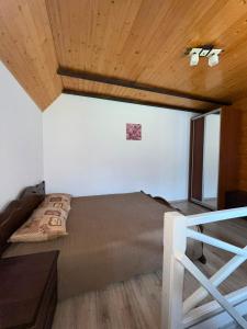 a bedroom with a bed and a wooden ceiling at Nice House in Slavske