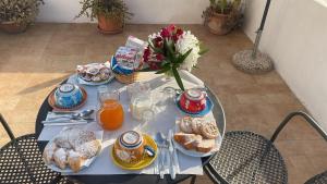 a blue table with breakfast foods and flowers on it at Agenzia Isotur Villa Olimpia in Ponza +57 photos