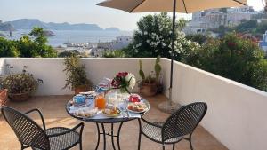 a table with food on a balcony with an umbrella at Agenzia Isotur Villa Olimpia in Ponza