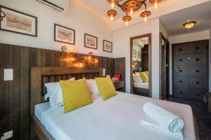 a bedroom with a large white bed with yellow pillows at Captain Stam Suites Athens - CityStudio in Athens