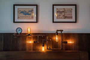 a clock on a wall next to a table with lights at Captain Stam Suites Athens - CityStudio in Athens