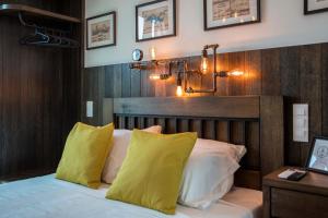 a bedroom with a bed with yellow and white pillows at Captain Stam Suites Athens - CityStudio in Athens