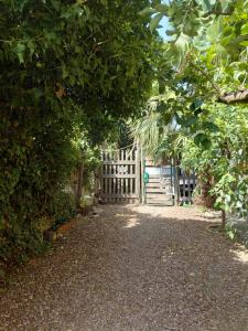 a gate in a garden with a fence and trees at Il Gelso Casa Vacanze in Piombino