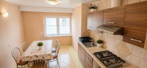 a small kitchen with a table and a stove at Nella - Pokoje gościnne in Ostrowo
