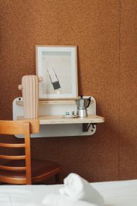 a shelf with a clock and a chair on a wall at Hotel Bistrot FINE in Anglet