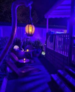 a patio with purple lights and a table and couches at Floriane in Claouey