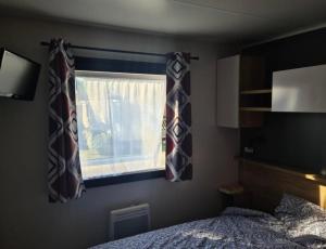 a bedroom with a bed and a window at Floriane in Claouey