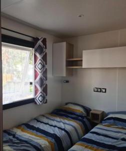 two beds in a small room with a window at Floriane in Claouey