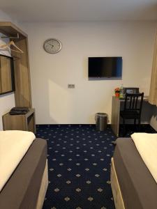 a hotel room with two beds and a flat screen tv at WaldGold Aparthotel in Nagold