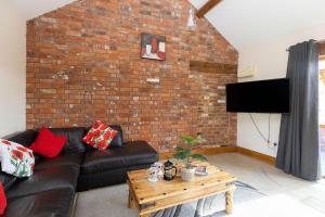 a living room with a couch and a brick wall at Blackberry Barn in Wotton-under-Edge +9 photos