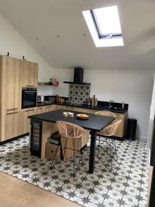 a kitchen with a black table and two chairs at Chambre bordée par le GR34 in Sibiril
