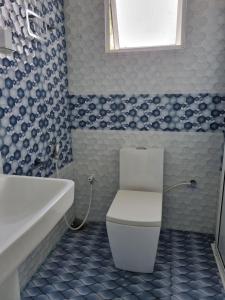 a bathroom with a toilet and a sink and a tub at Wings Hotel & Hostel in Trincomalee