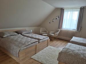 a bedroom with two beds and a window at Kriszta Gold Vendégház in Újfehértó