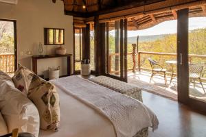 a bedroom with a bed and a balcony at Tshwene Lodge in Vaalwater +49 photos