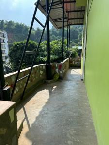 a balcony of a building with a view of trees at Luna's Solace-The Rustic Stay-Ease in Guwahati