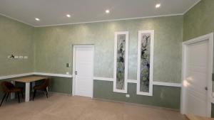 a room with a table and three paintings on the wall at Tenuta MAREALE in Anzio