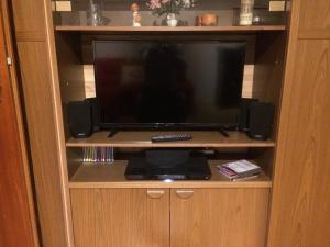 a television in a wooden entertainment center with speakers at Grubhof in Sankt Martin bei Lofer
