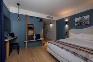 a bedroom with a bed with blue walls and a table at Hôtel Restaurant la Couronne in Chamonix