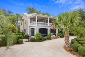 an exterior view of a house with palm trees at A Wave From It All - 811 Ocean Blvd in Saint Simons