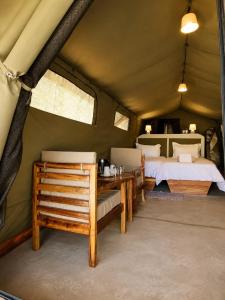 a bedroom with a bed and a table in a tent at Omulunga Bush Camp in Ruacana
